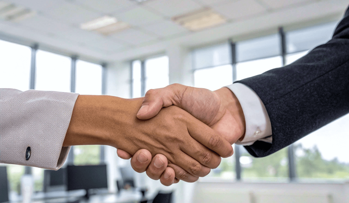Business handshake in office — partnership and collaboration