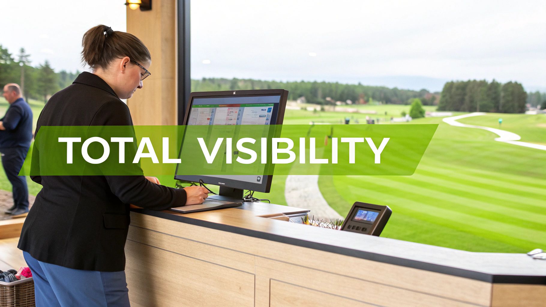 Woman at a golf club reception desk using a computer with a view of the course.