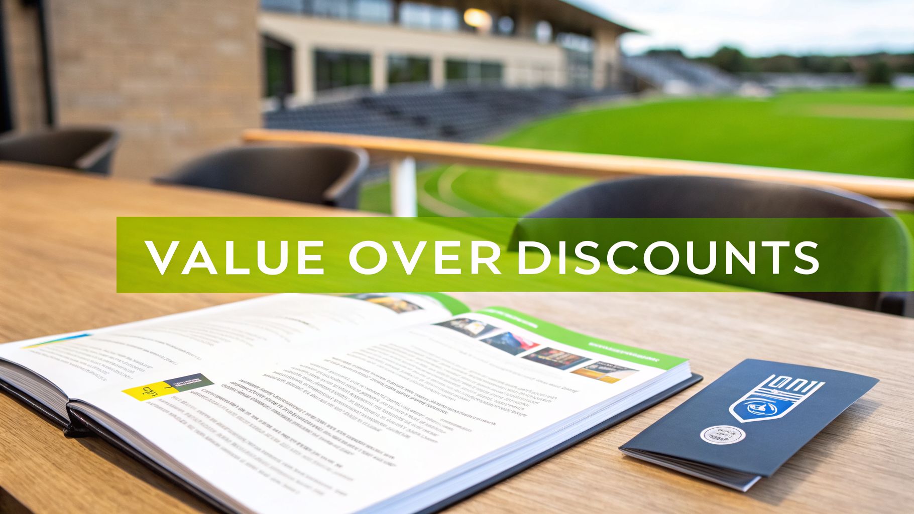 Text 'VALUE OVER DISCOUNTS' on a green banner, with books on a table overlooking a stadium.