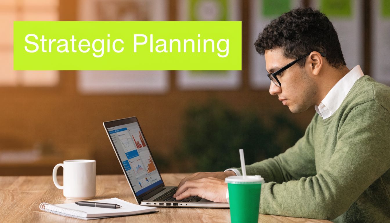 A focused man wearing glasses works on a laptop computer for his strategic planning business task.