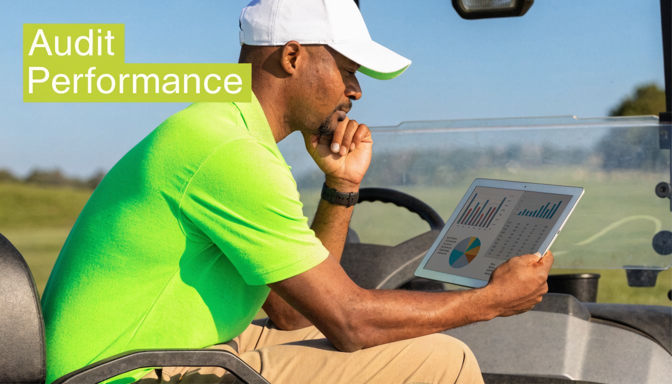 A golf course manager sits in a cart reviewing performance data on a tablet computer.