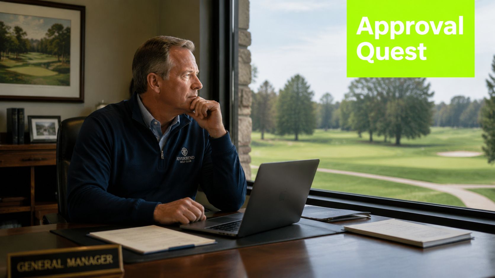 A professional golf club manager sits at his desk looking out the window at the green course.
