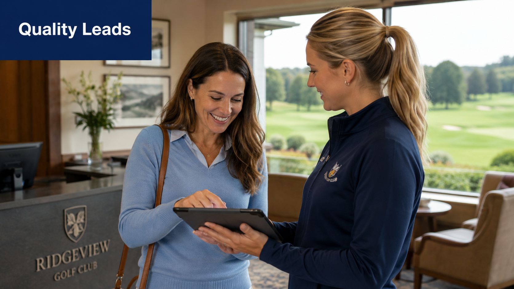 A woman at a golf club reception desk showing a digital tablet to a visitor.