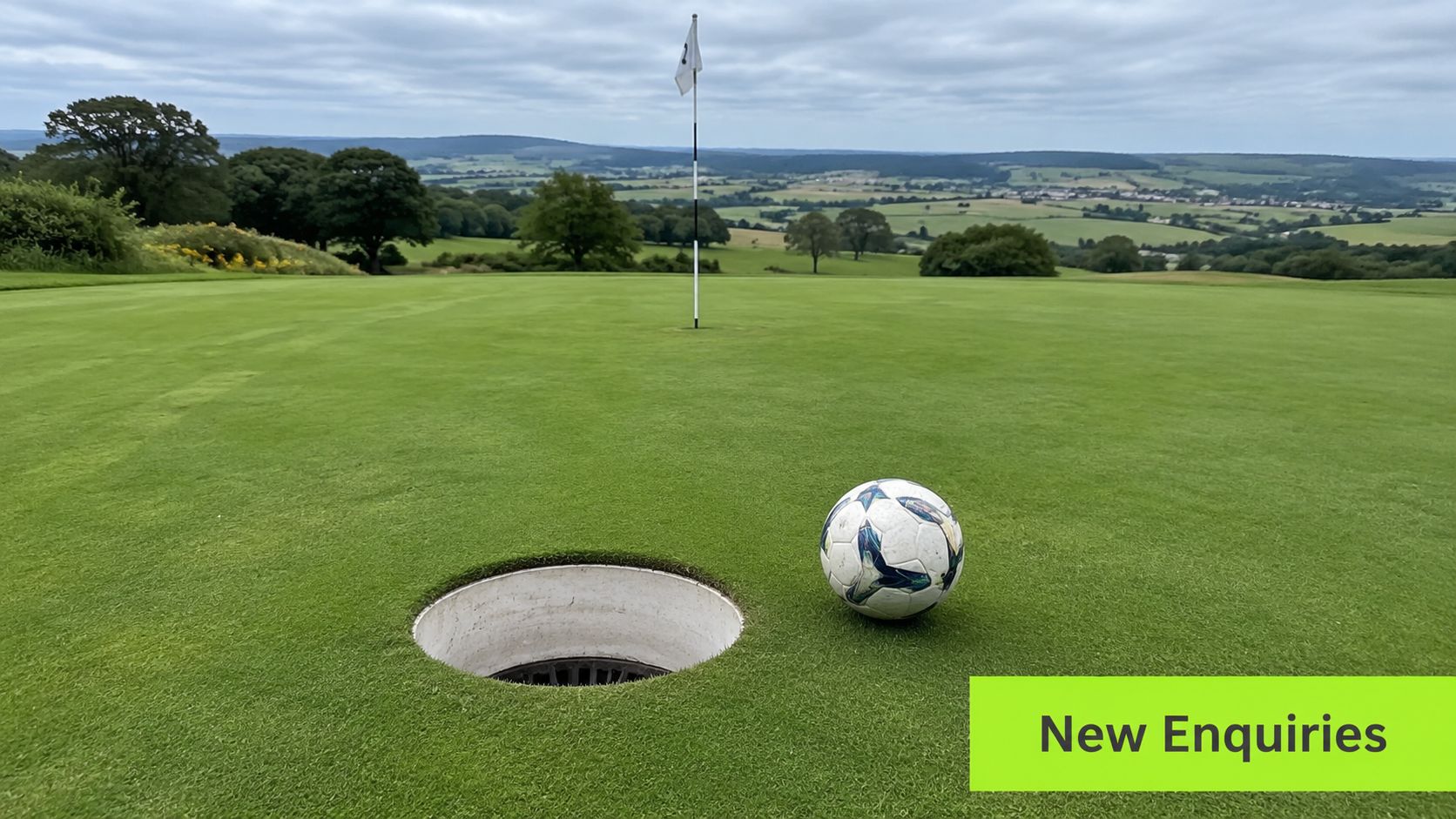 A soccer ball resting on a green golf course near a hole with a flag in background.