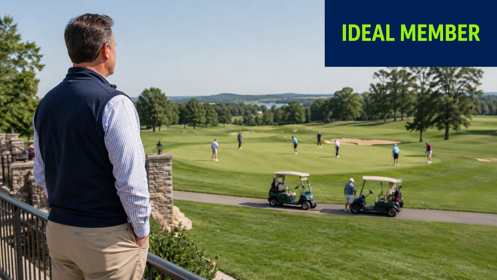 A man stands on a patio overlooking a beautiful green golf course with players on the field.