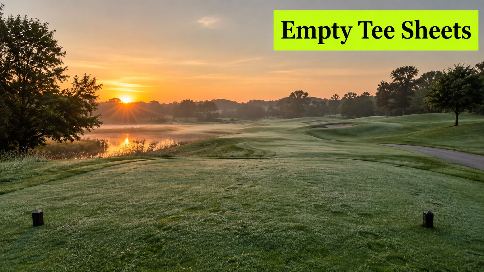 A serene golf course landscape at sunrise with a misty lake and morning light over the fairway.