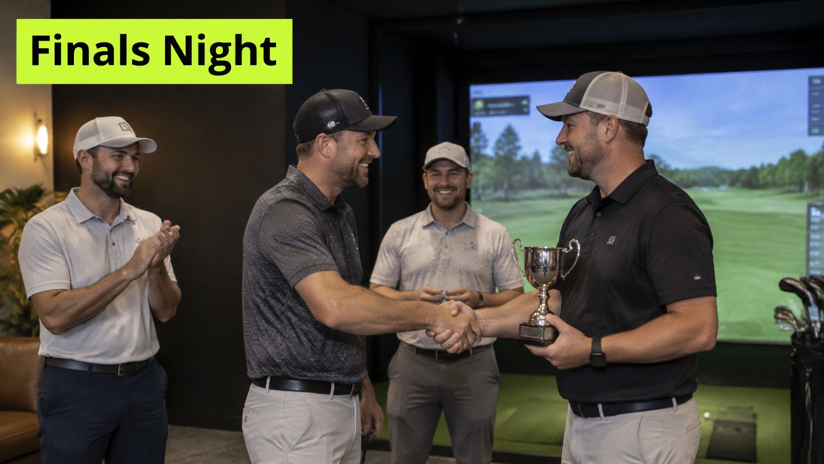 Two men shake hands while holding a golf trophy as two others watch in an indoor simulator.