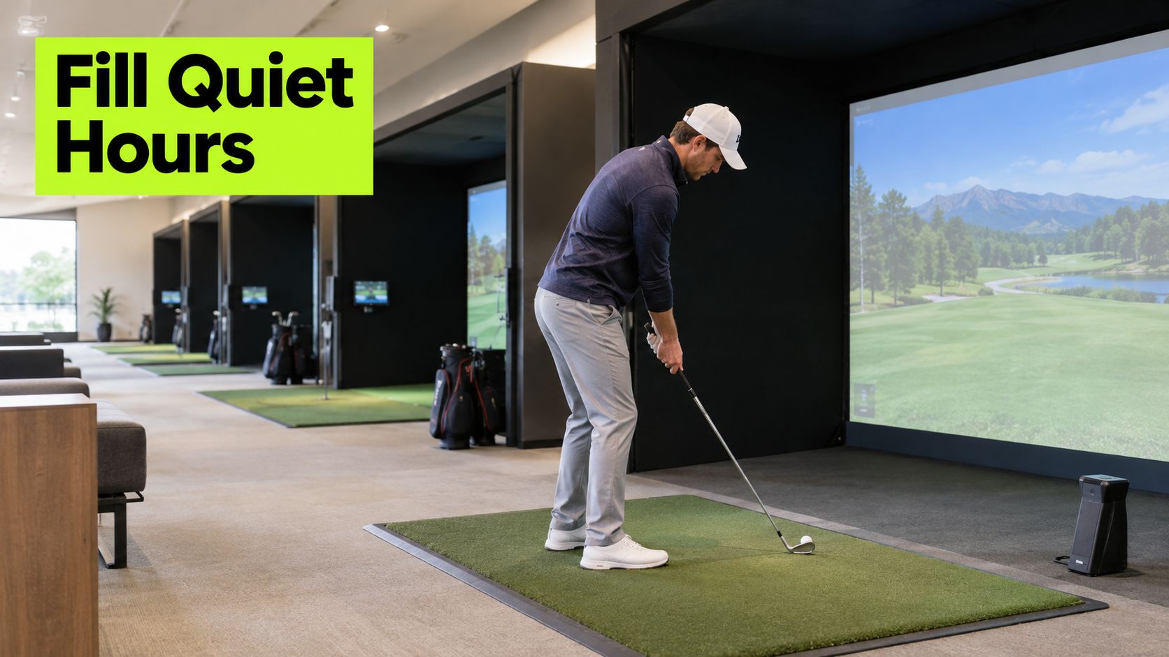 A man practising his golf swing in an indoor golf simulator studio with several hitting bays.