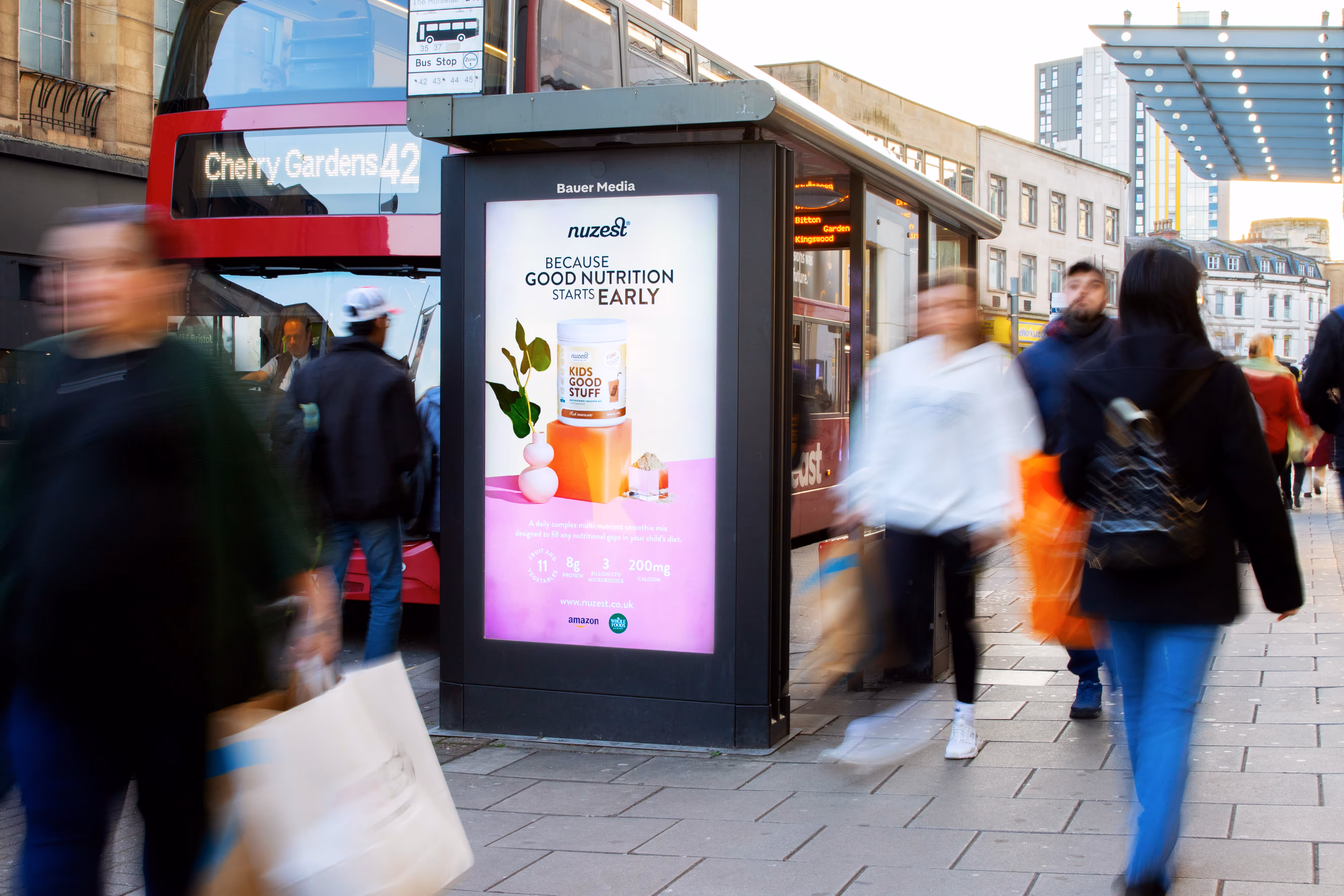 Nuzests multi nutrient mix Adshel Live Bus Shelter advertisement surrounded by bustling shoppers