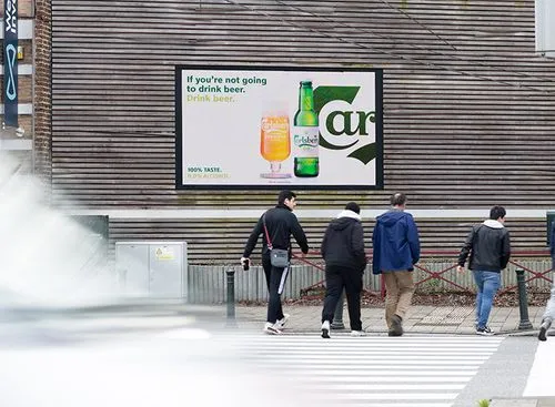 4 men walk past a billboard