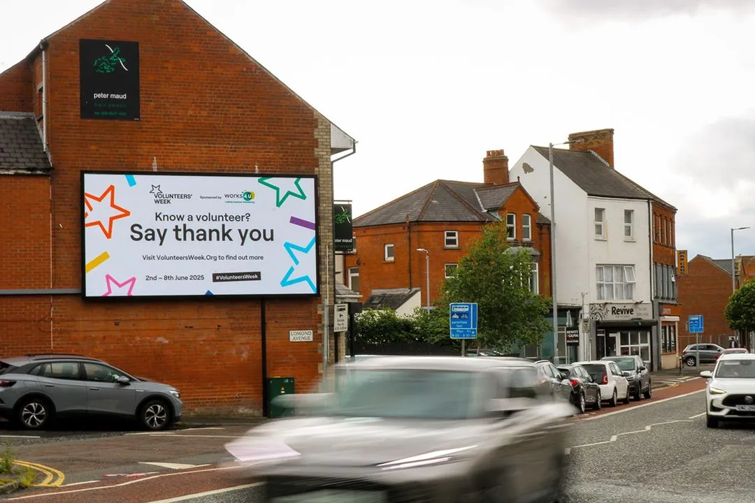 a digital billboard screen located on a busy road with traffic passing by