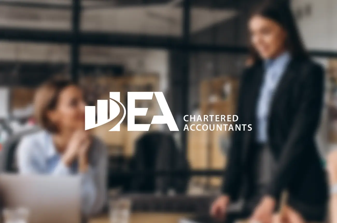 EA Chartered Accountants logo on blurred office backdrop