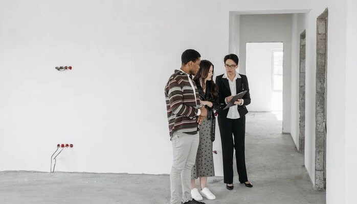 Trois personnes étudient un dossier dans un appartement en cours de rénovation