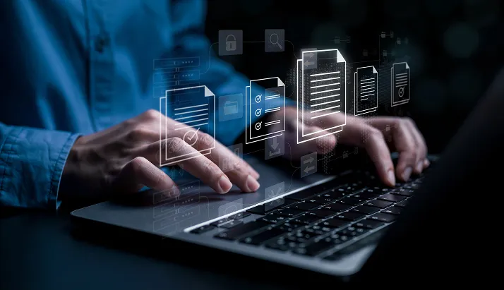 Person typing on a laptop keyboard with digital document icons floating above.