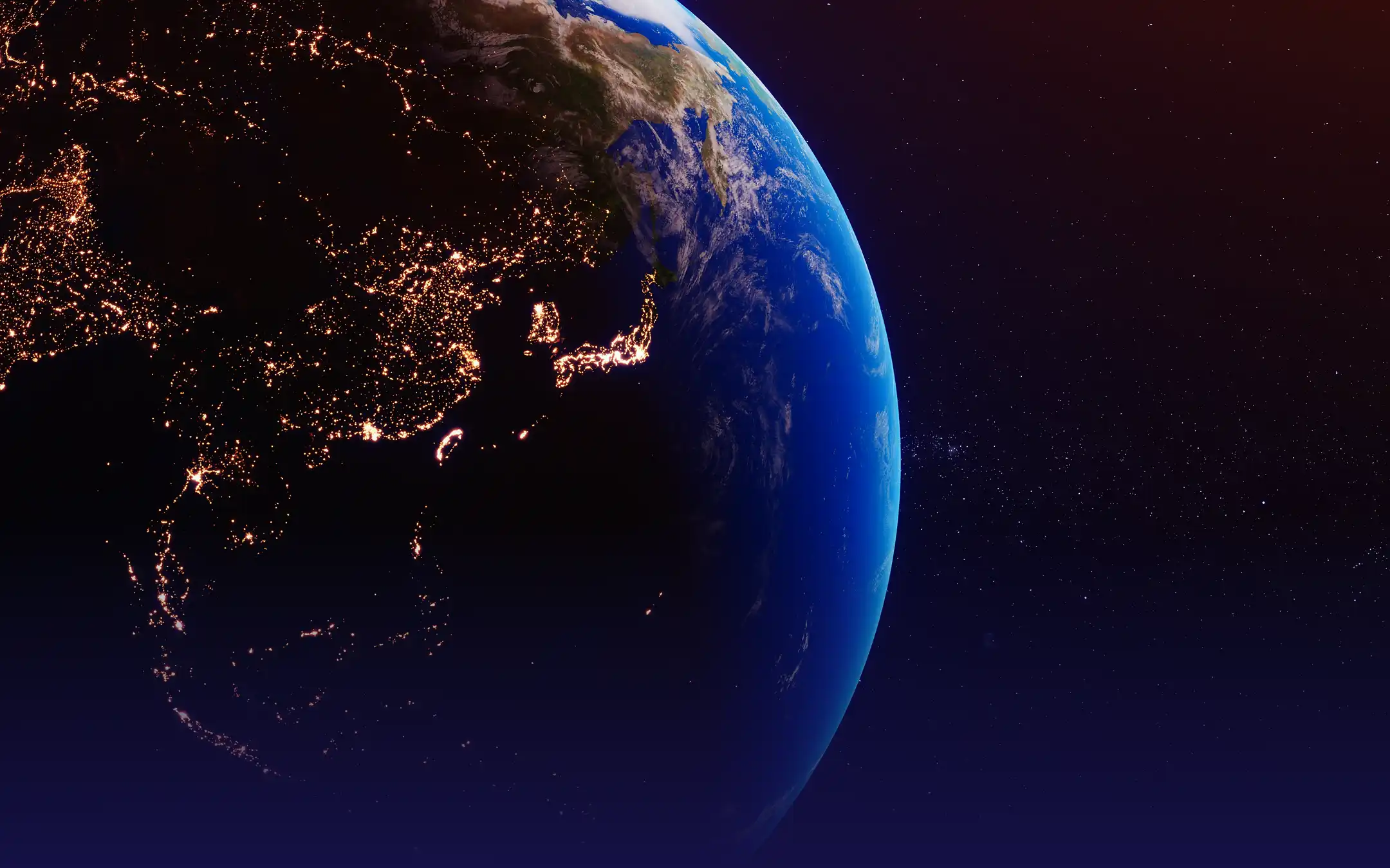 View of Earth from space showing the night side illuminated with city lights across East Asia and Japan.