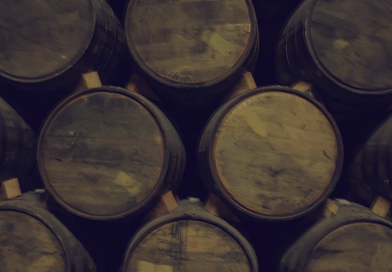 Close-up aerial view of stacked wooden barrels used for aging or storing liquids.