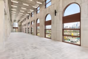 Spacious modern interior hallway with large arched windows overlooking a cityscape.