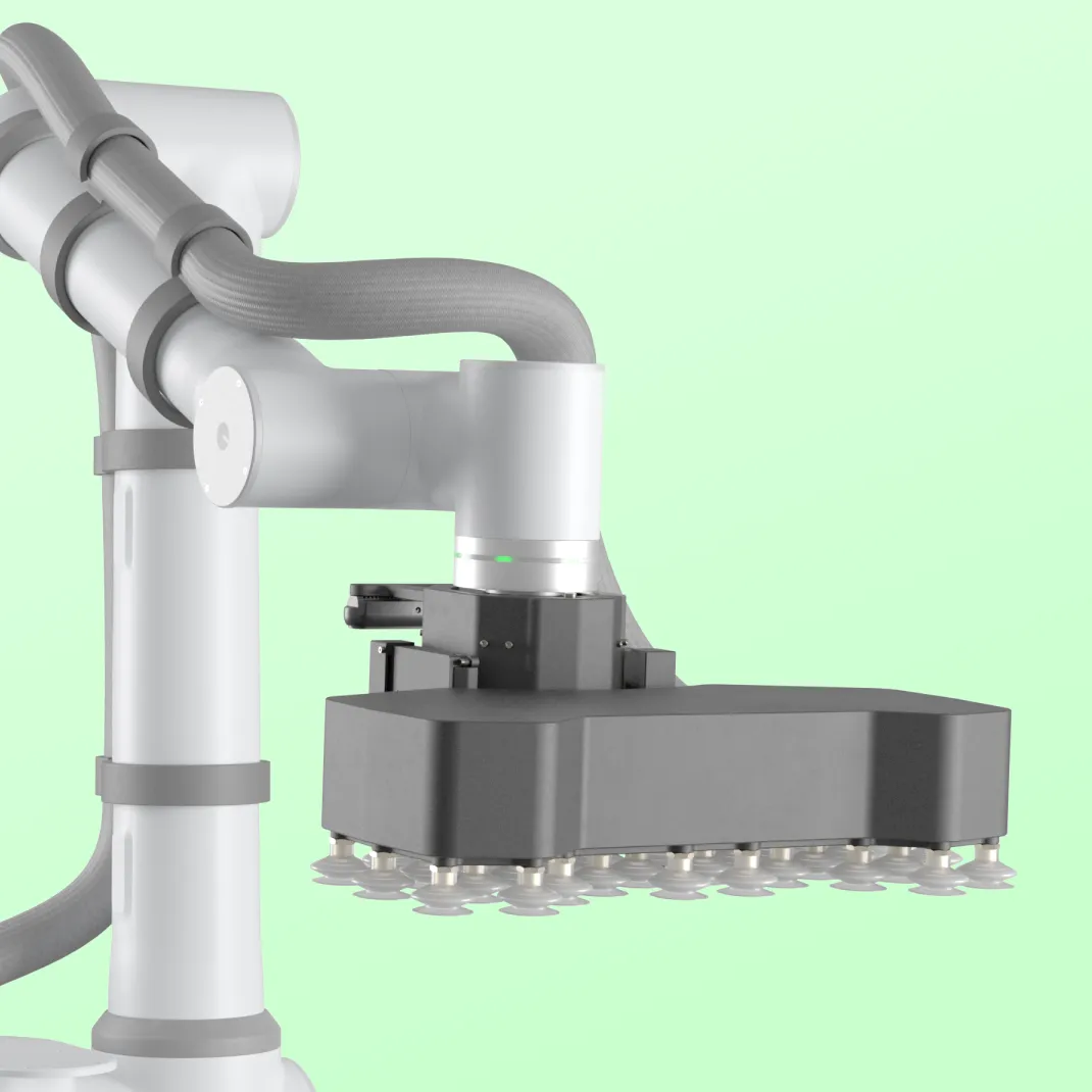 Robotic arm with a flat suction gripper featuring multiple suction cups against a pale green background.