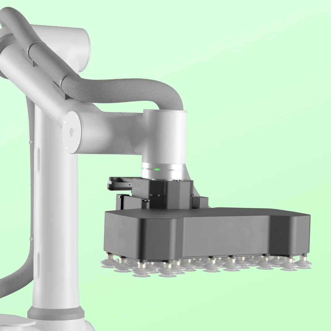 Close-up of a robotic arm with a black rectangular vacuum gripping tool against a light green background.