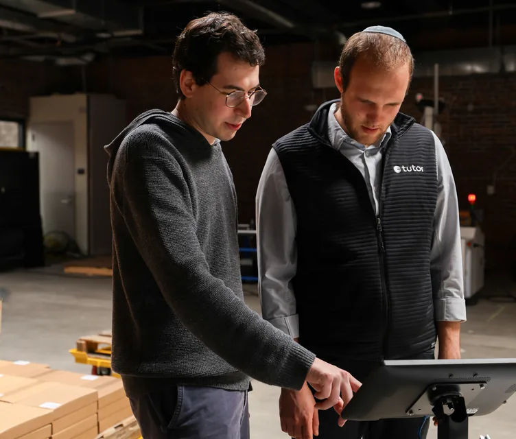 Two people reviewing Cassie's control tablet together during a robot deployment.