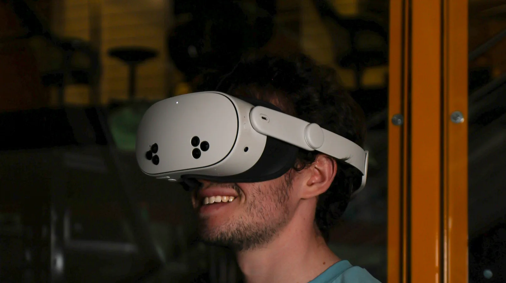 A Tutor researcher wearing a VR headset, teleoperating a robot on the warehouse floor.