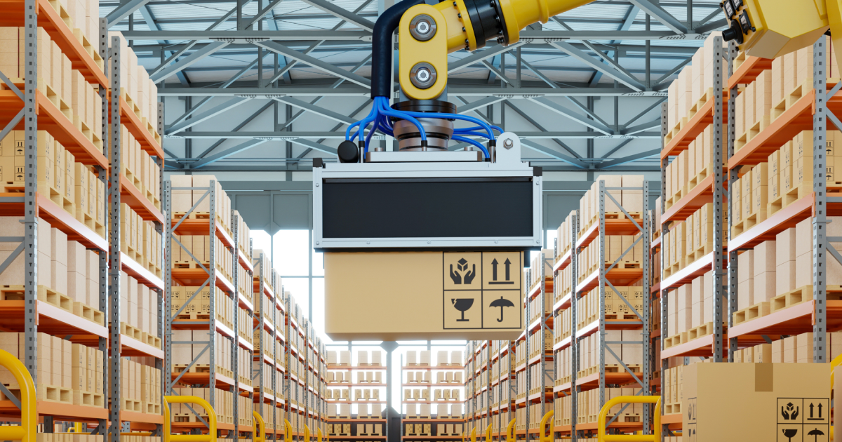robotic arm lifting a cardboard box in a warehouse aisle