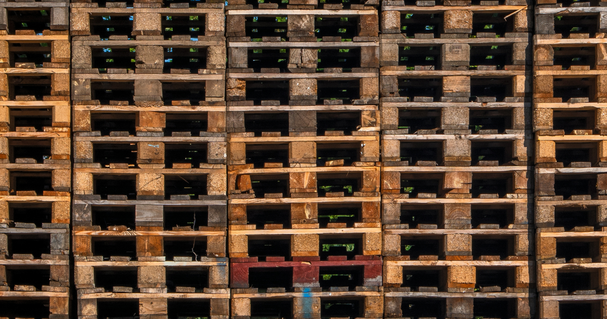 stack of weathered wooden pallets arranged in a tight grid