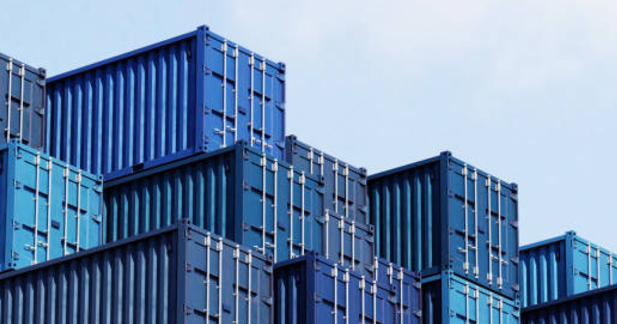 stacked blue shipping containers against a clear sky