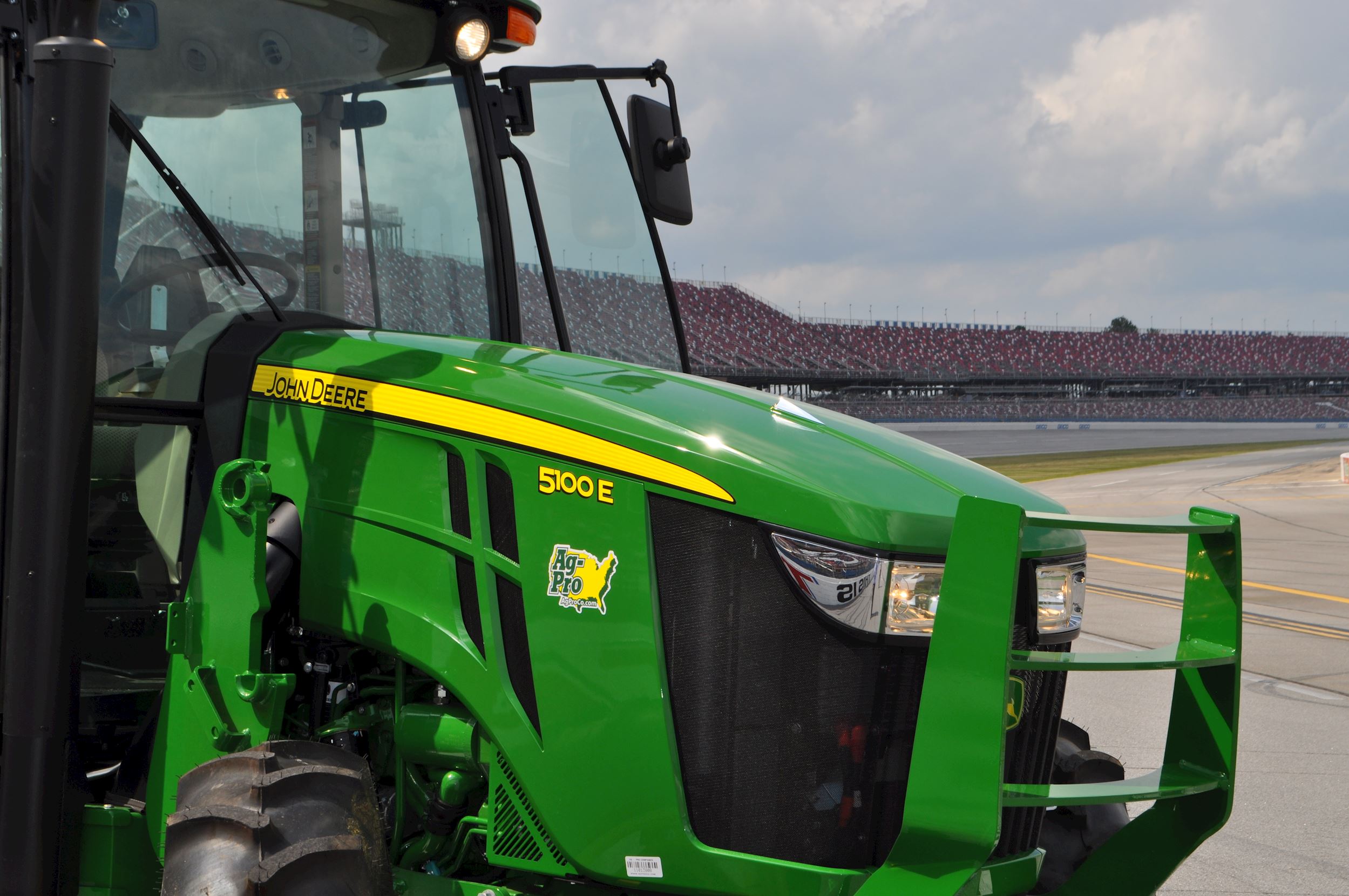 A John Deere 500E tractor is photographed in front of the track at Talladega.