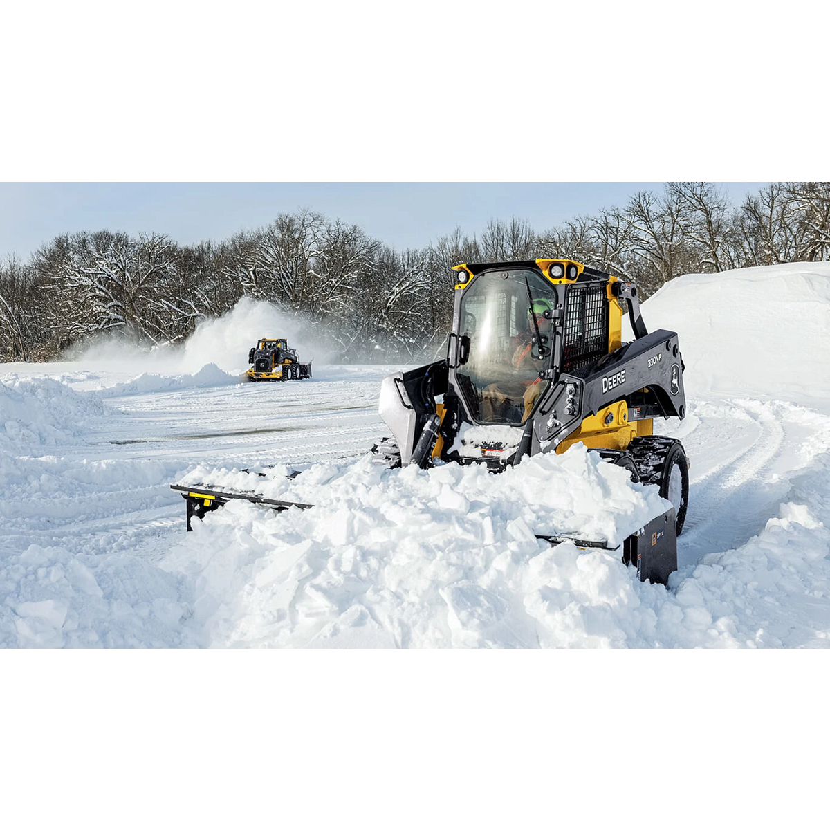 330 P-Tier skid steer moving snow with Deere snow pusher attachment.