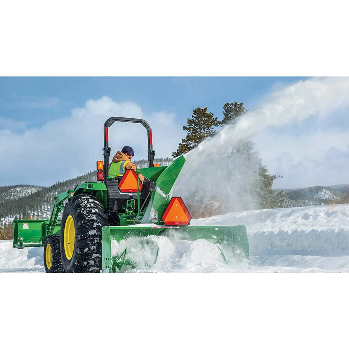 A person clearing snow using a 4052M Compact Tractor with a snow removal attachment