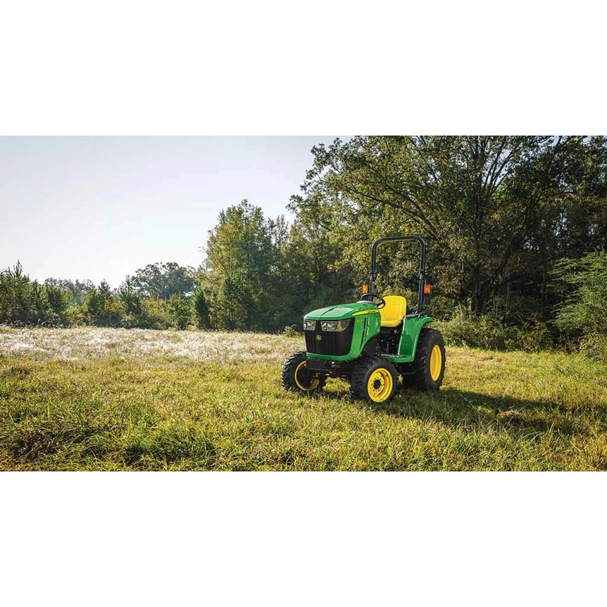 3025E 3 Series Compact Tractors with a green tractor parked in a field with trees in the background