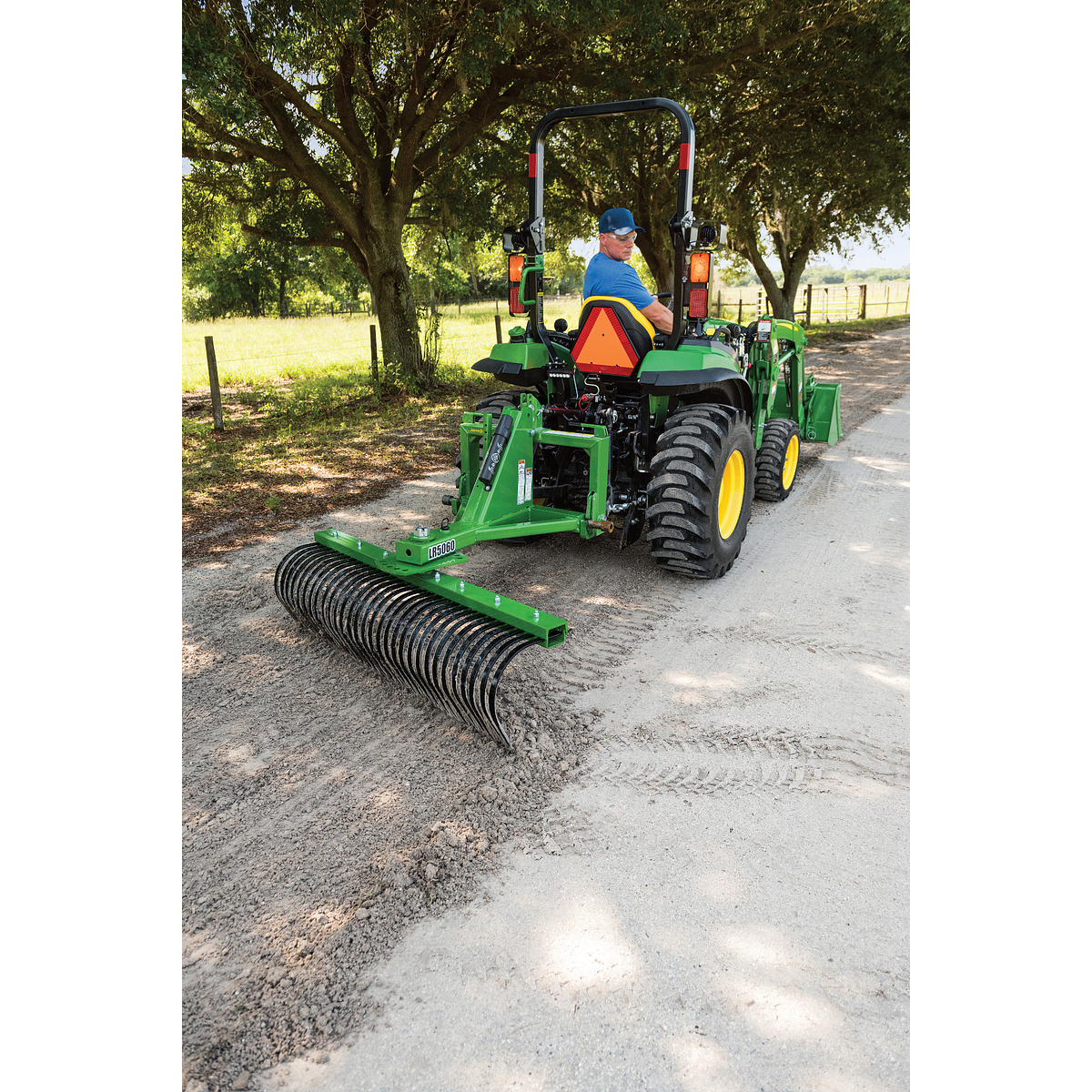 2032R Tractor raking dirt on a driveway using a LR5060 Landscape Rake