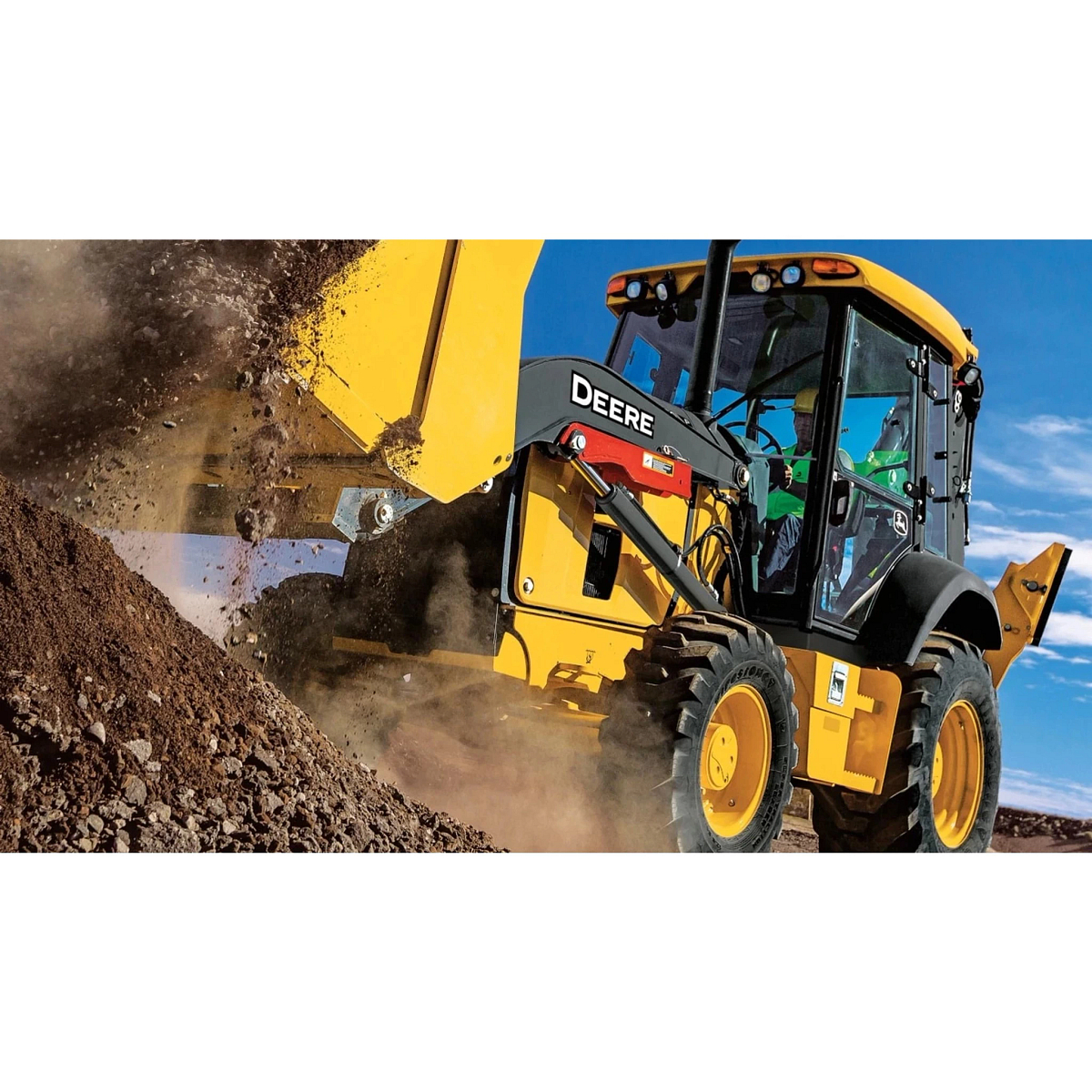 310 G-Tier Backhoe Loader dumping dirt and gravel into a large pile