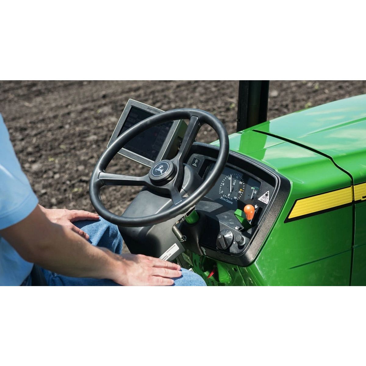Tractor in a field with a focus on the steering wheel
