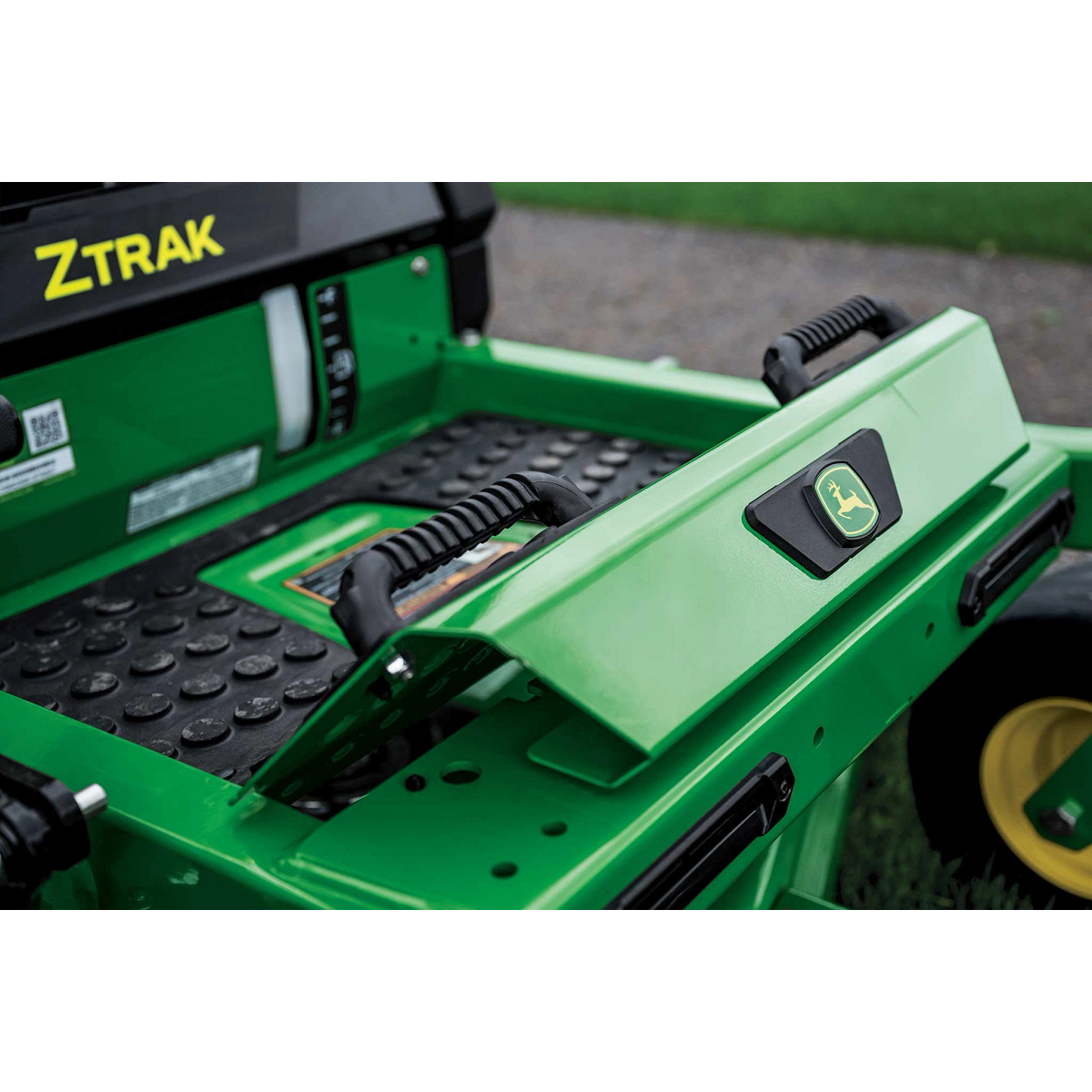 A zoomed-in shot of the foot rest of a green zero-turn mower.