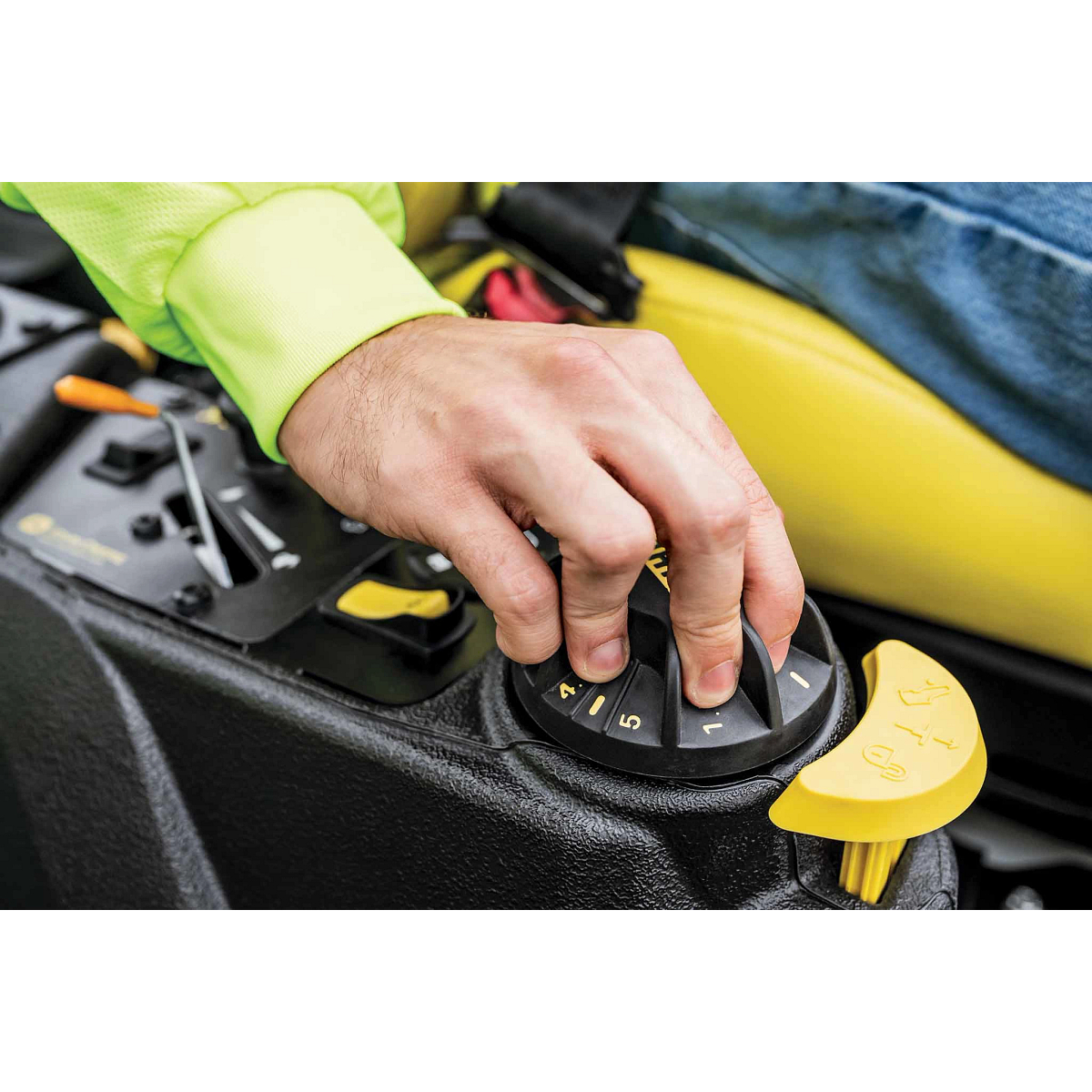 A zoomed-in shot of a landscaper’s hand operating the right-hand console of a Z740M zero-turn mower.
