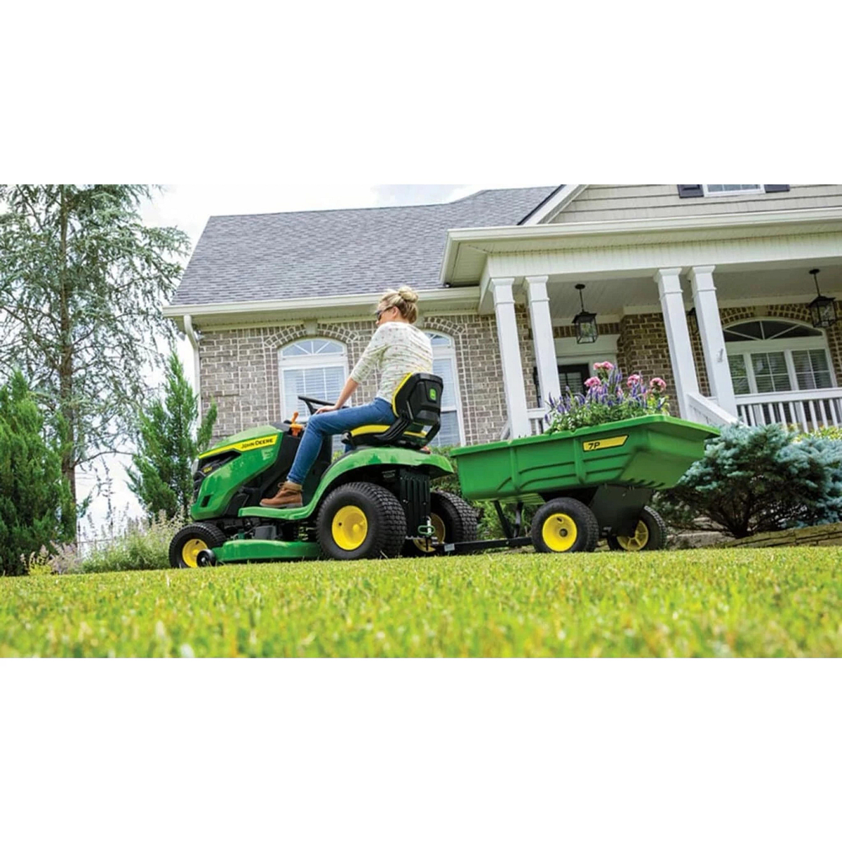 Homeowner mowing with an S120 Lawn Tractor towing a wagon