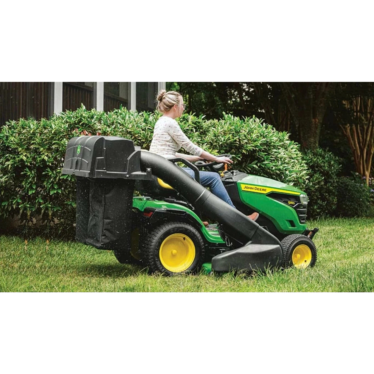 Homeowner mowing a yard with an S180 Lawn Tractor with a bagger attachment