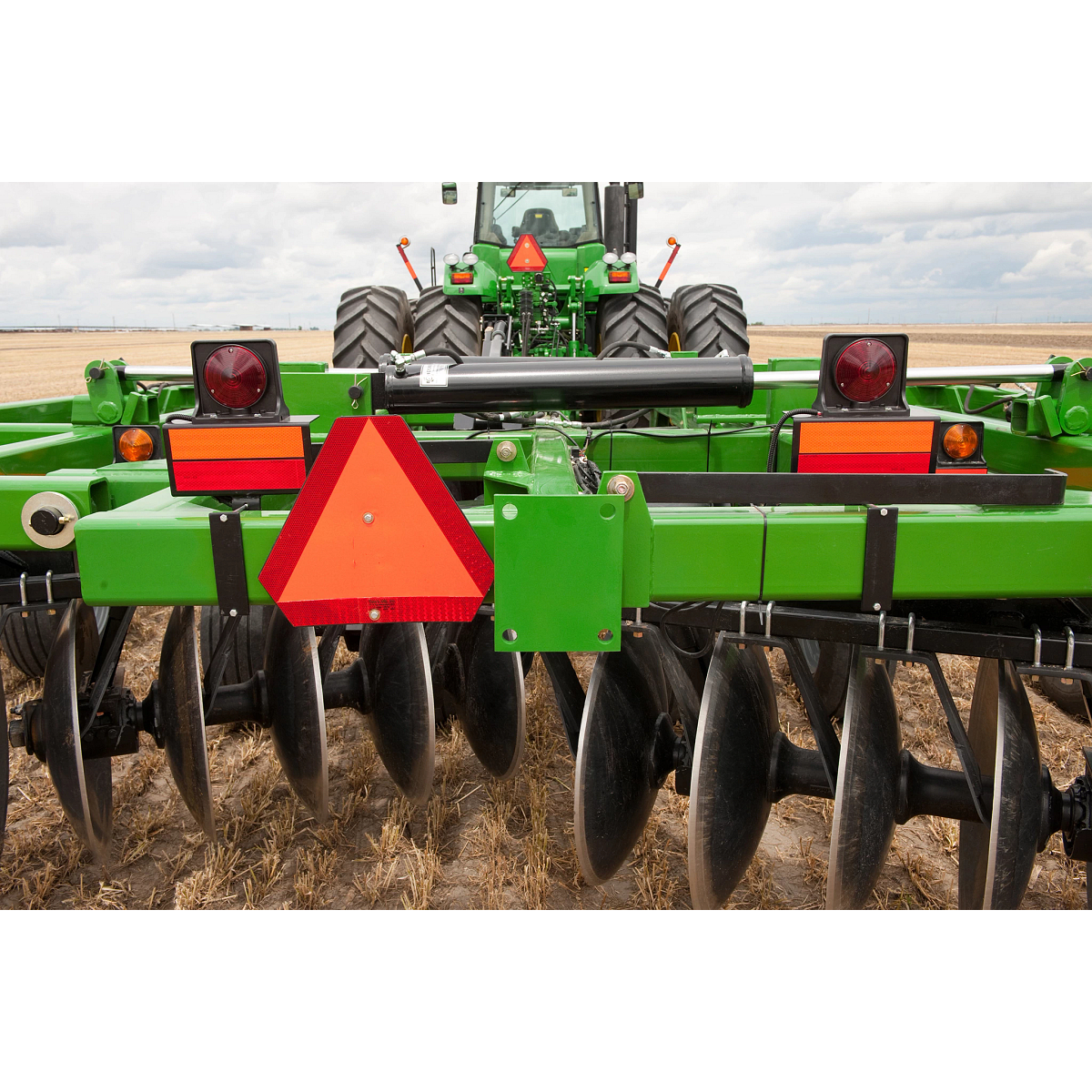 Close-up rear view of a tractor pulling a Frontier Tandem 51 Series Disk Harrow in the field