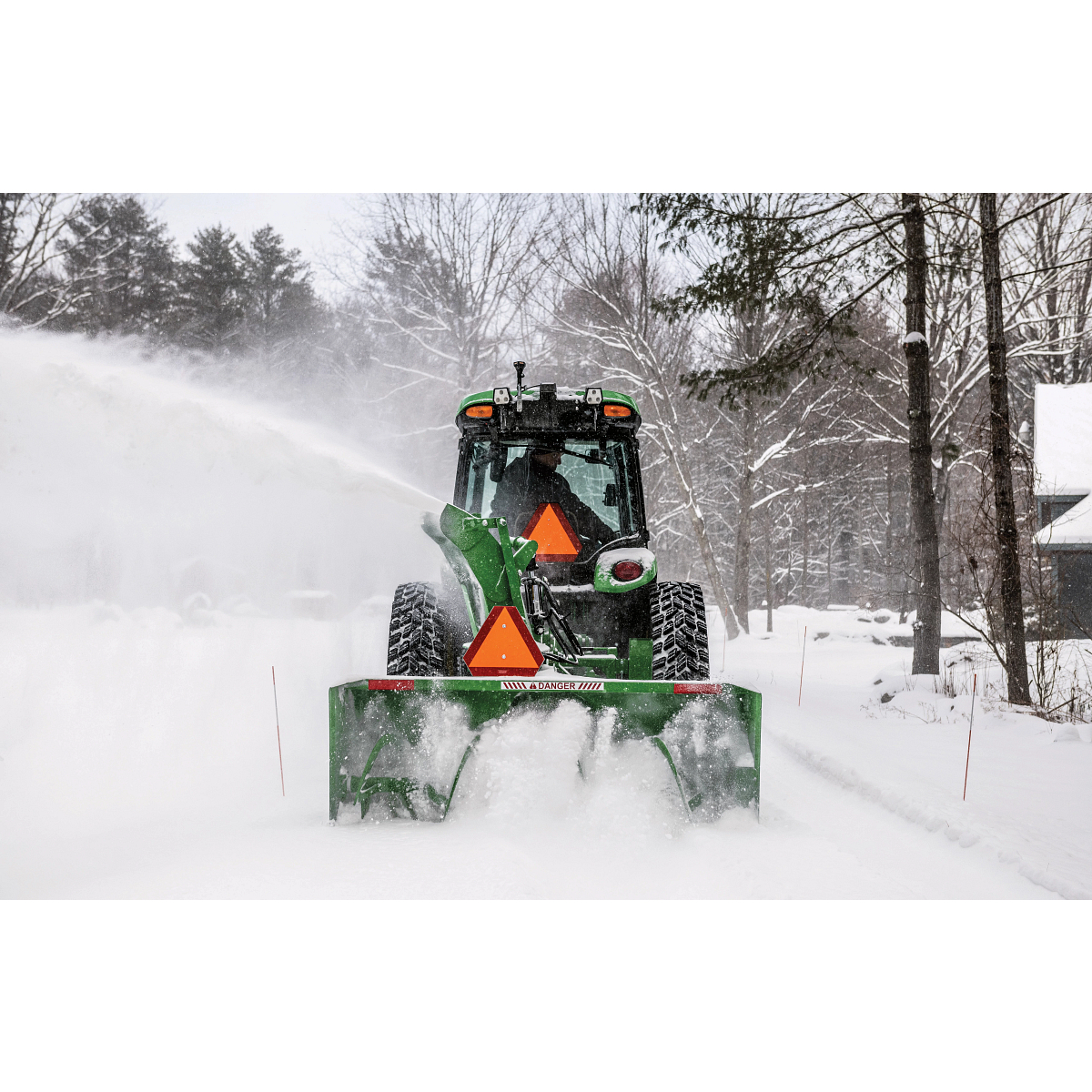 Rear view of a SB1280 Snowblower on a 4075R Tractor blowing snow on a driveway
