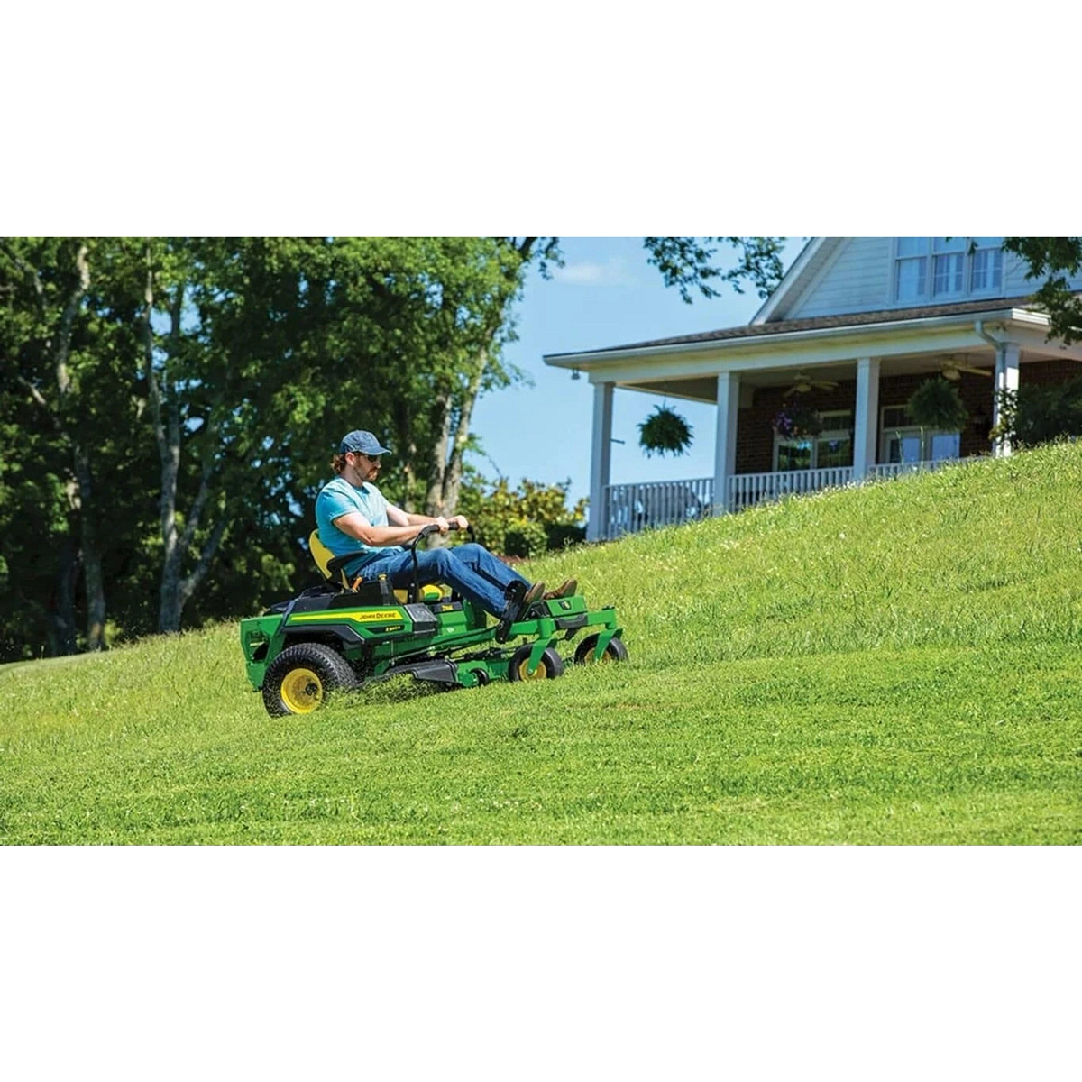 Homeowner mowing a grassy hill with a Z330R ZTrak Mower in front of a house