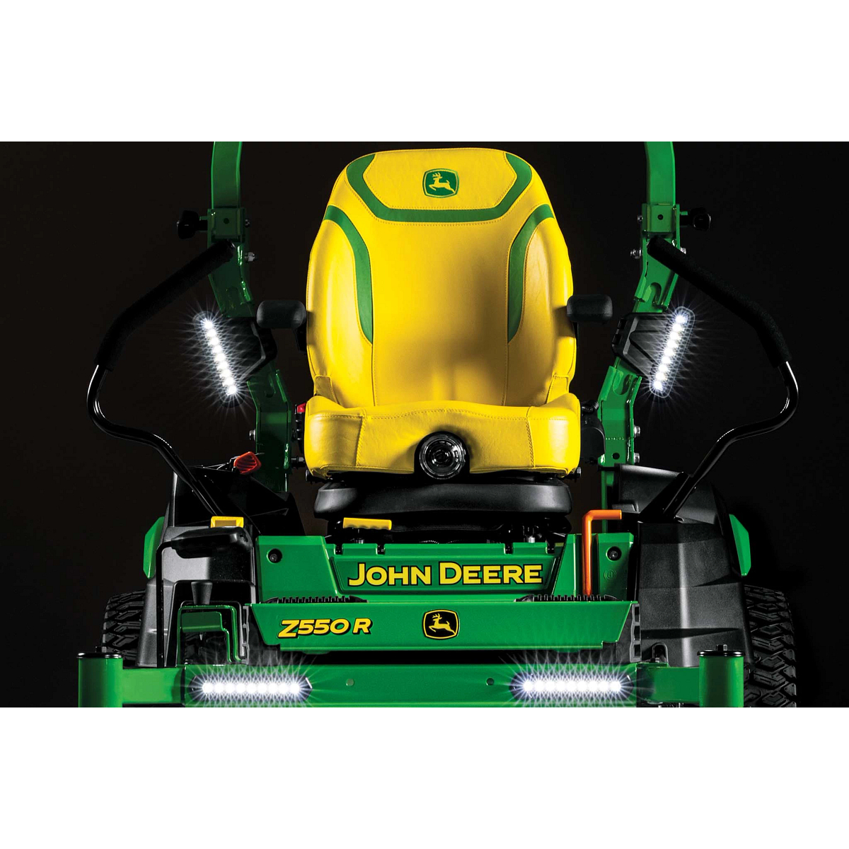 A dramatic close-up front shot of the yellow seat and LED lights on a Z550R zero-turn mower with a black background.