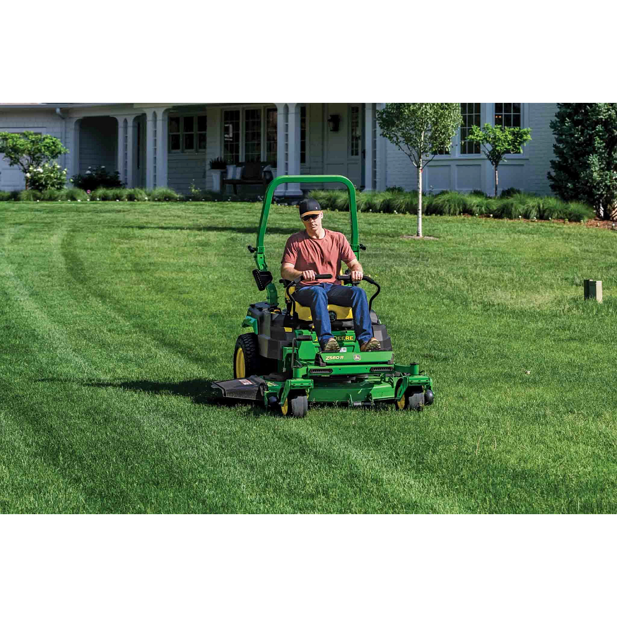A Z560R zero-turn mower is used to mow the large front lawn of a residence.