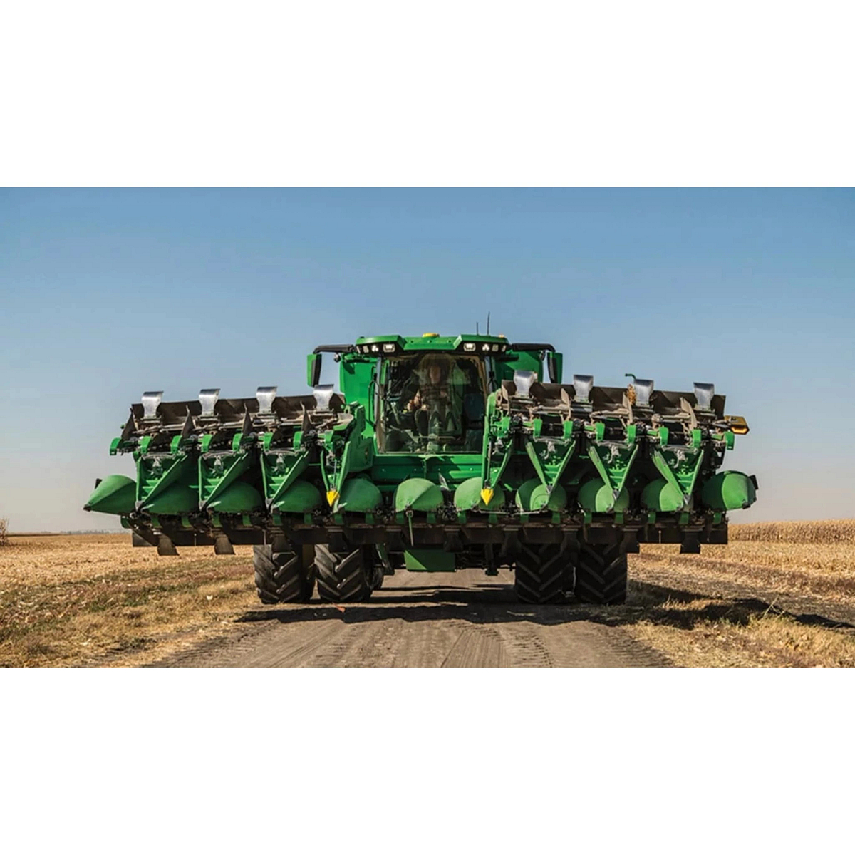 Front view of a combine in a harvested corn field