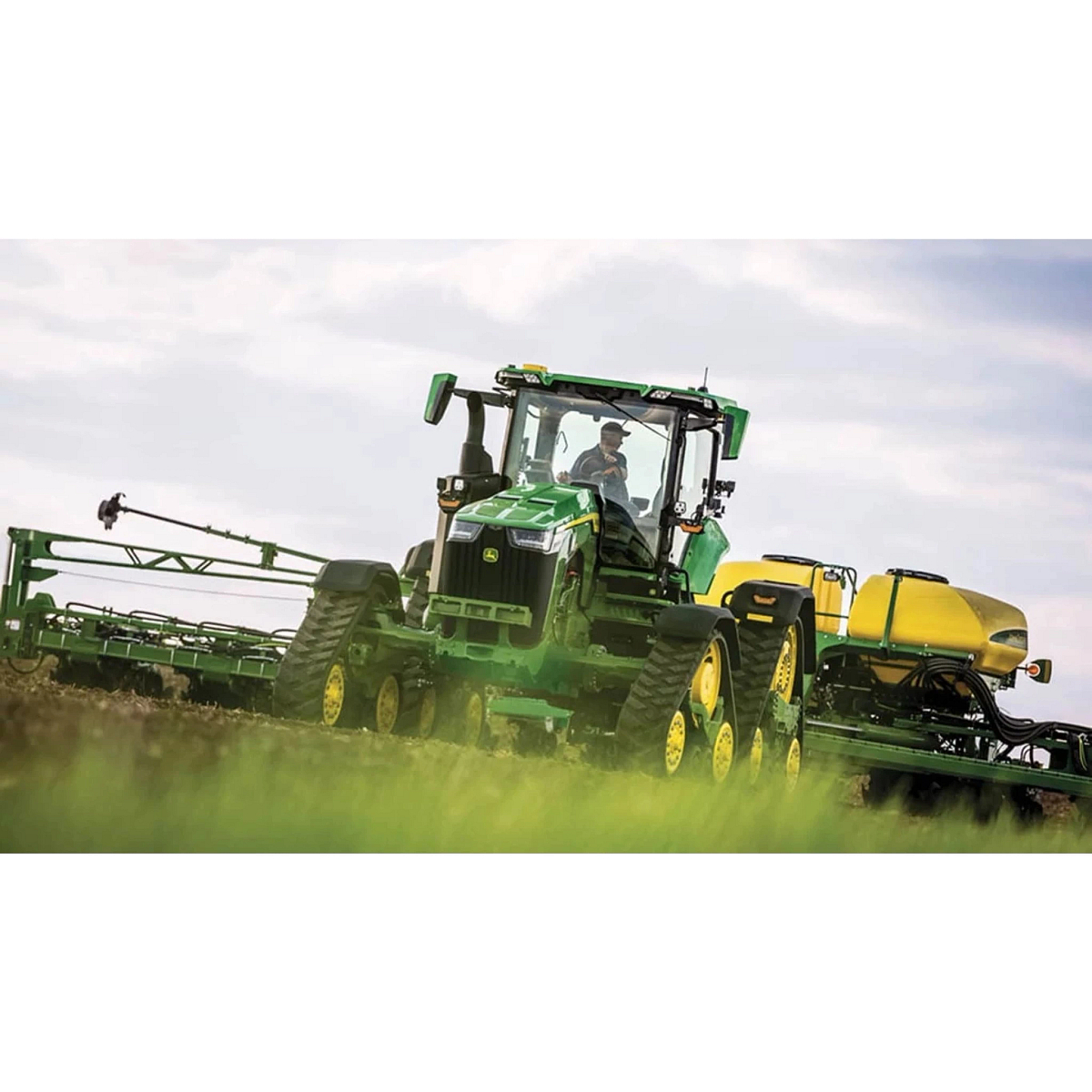 8RX 340 Four-Track Tractor pulling a sprayer attachment