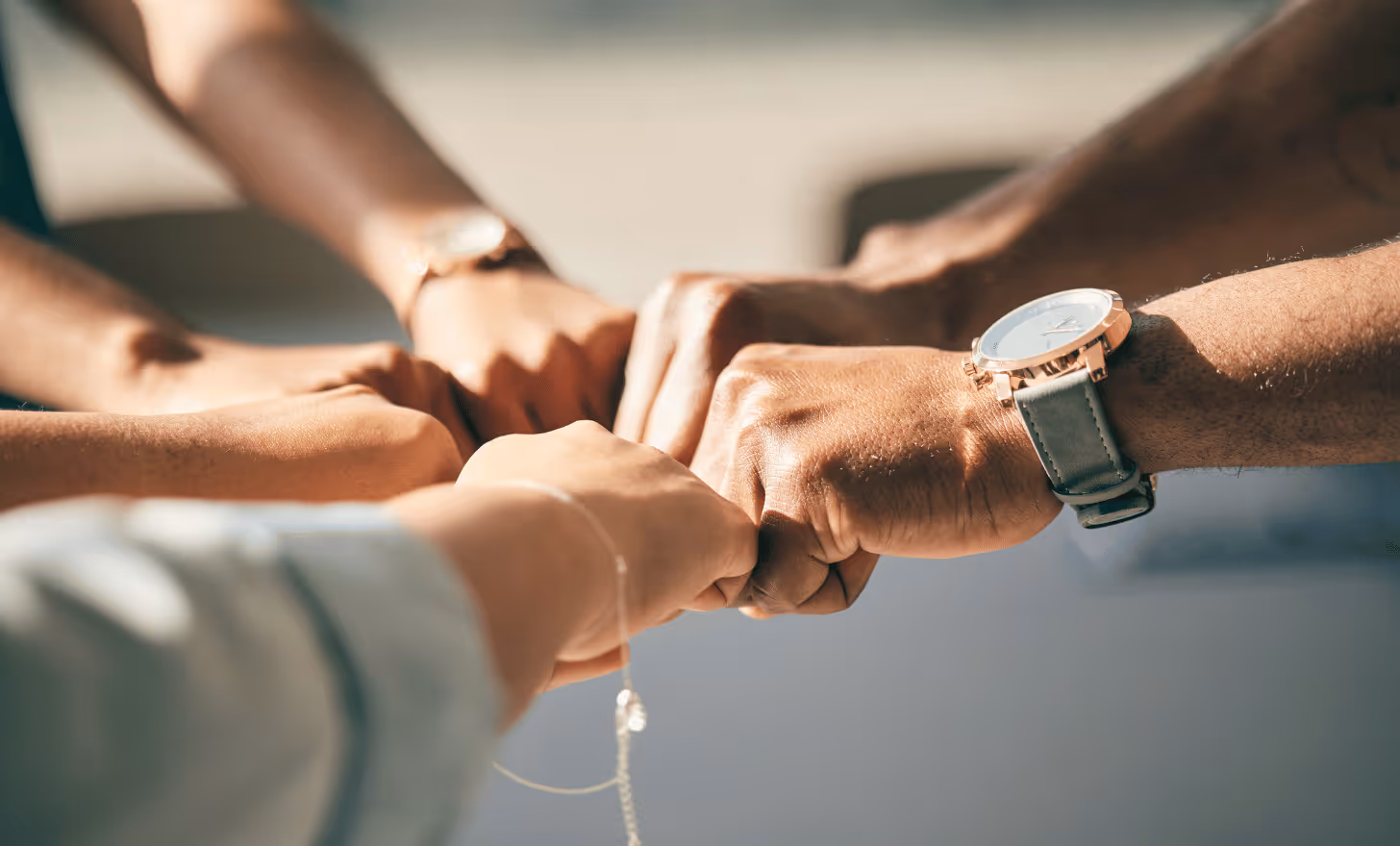 Plusieurs poings se rejoignant pour un geste d'unité et de collaboration.