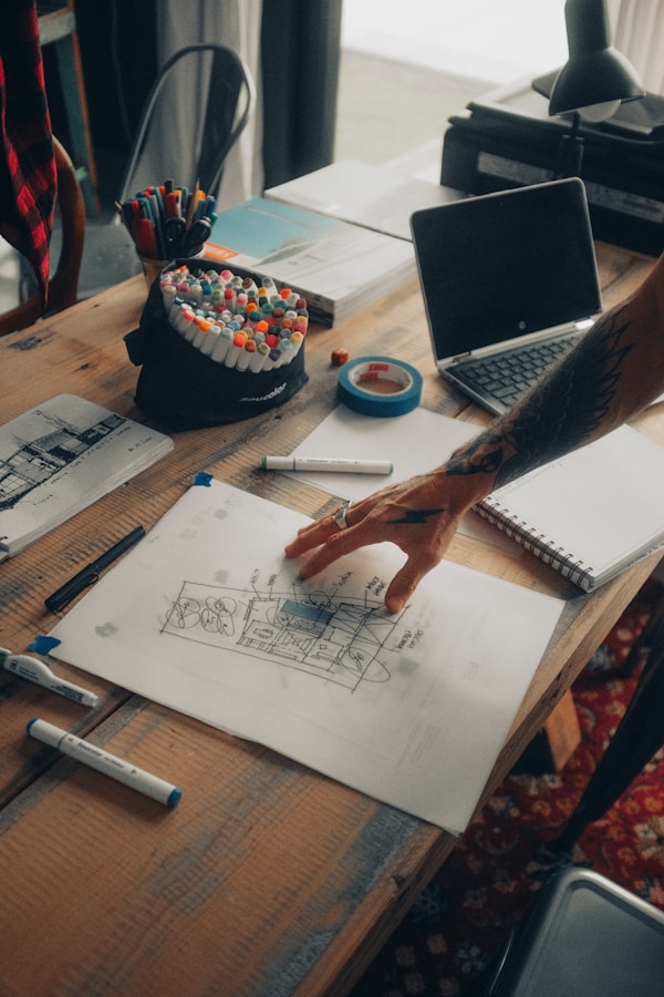 A person assessing a floor plan of a commercial building. Hand over the desk. 