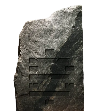 Dark rough stone slab with faint, partially obscured carved horizontal lines.