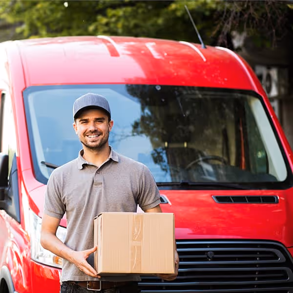 Delivery driver in front of red van.